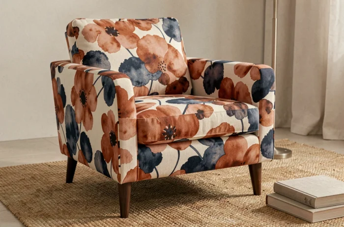 Fauteuil retapissé d'un tissu d'ameublement imprimé en print-on-demand avec un motif floral abstrait en terracotta, indigo et crème dans un salon contemporain.